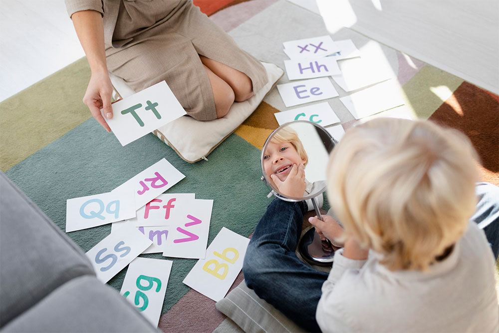 young-woman-doing-speech-therapy-with-little-blonde-boy